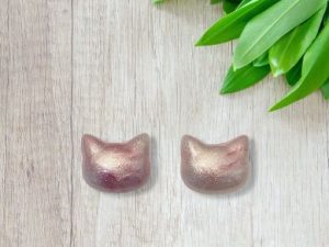 Paire de boucles d’oreilles puces/clous, en forme de tête de chat, blanches et roses nacré.